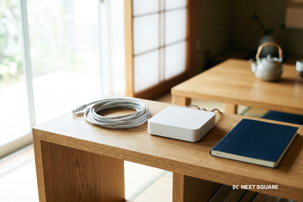 リビングの棚に置かれたWi-Fiルーターと、束ねられたLANケーブルの様子(画面表示なし)