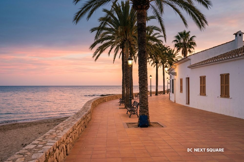 夕暮れのスペインの海辺のヤシ並木のプロムナードのイメージ
